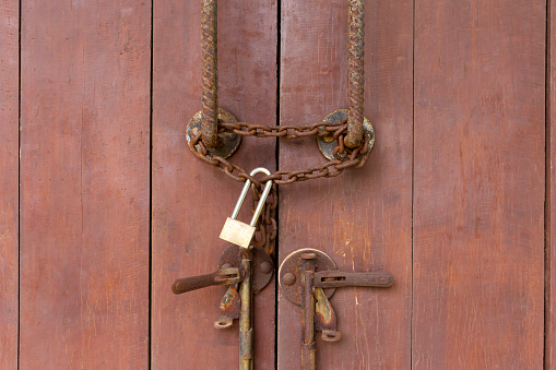 Closed padlock hangs on the old doors.