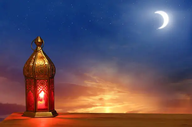 Islamic greeting Eid Mubarak cards for Muslim Holidays.Eid-Ul-Adha festival celebration.Arabic Ramadan Lantern on wooden table.Decoration lamp. Crescent moon and the stars.