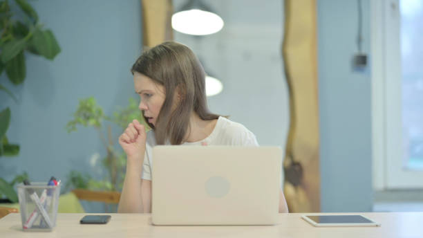 istock Coughing Sick Casual Young Woman Working on Laptop 1470700372