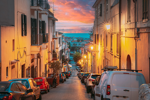 Terracina, Italy. Cars Parked On Narrowm Street In European City In Summer Night. Amazing Sunset Sky With Saturated Colorful Clouds. Scenic View. Travel Italy.