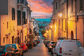 Terracina, Italy. Cars Parked On Narrowm Street In European City In Summer Night. Amazing Sunset Sky With Saturated Colorful Clouds. Scenic View. Travel Italy