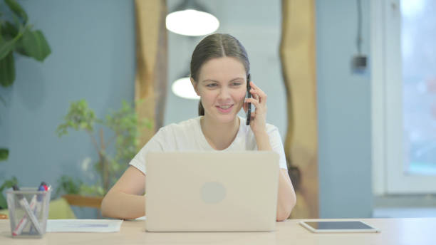 istock Casual Young Woman Talking on Phone to Discuss Work 1470700473