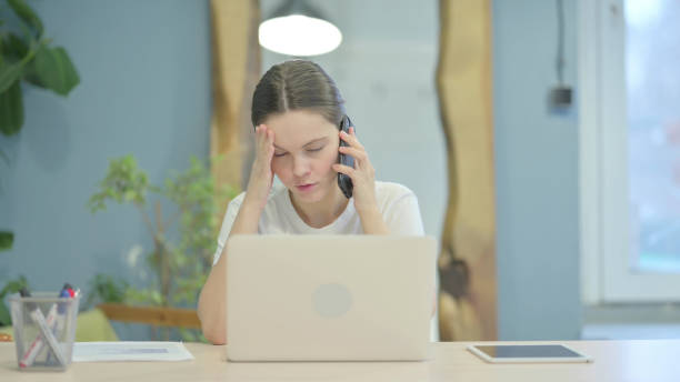 istock Angry Casual Young Woman Talking on Phone at Work 1470700494
