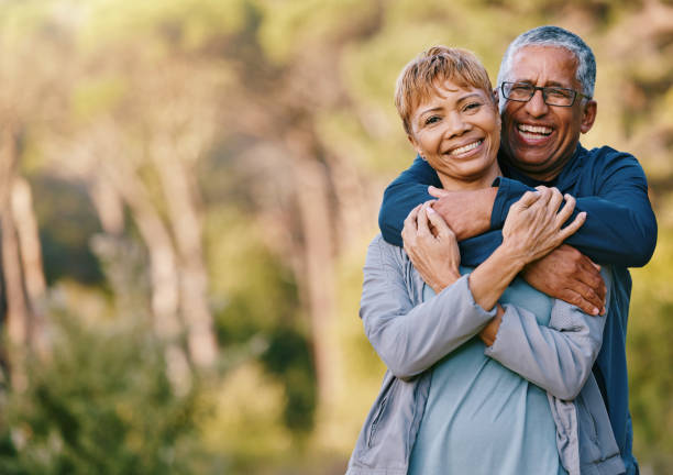 nature, love and portrait of a senior couple hugging in a garden while on romantic outdoor date. happy, smile and elderly people in retirement embracing in park while on a walk for fresh air together - smile happy imagens e fotografias de stock