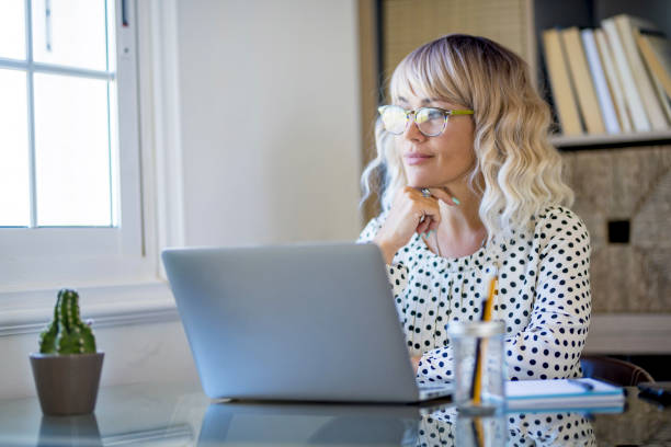 istock Thoughtful serene business woman looking away thinking solving problem at work, happy smiling young middle age woman relax lost in thought reflecting sit with laptop. Lifestyle of businesswoman 1470702318