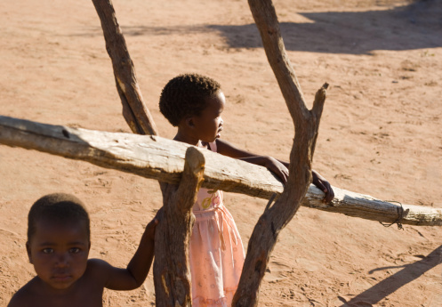 brother and sister hanging out in the yard in an village near Kalahari desert