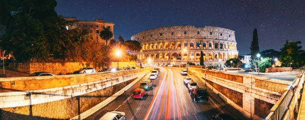 rome, italy. colosseum also known as flavian amphitheatre. traffic in rome near famous world landmark unesco in evening time. amazing bright night starry sky background. dark blue sky. travel italy - flavian imagens e fotografias de stock