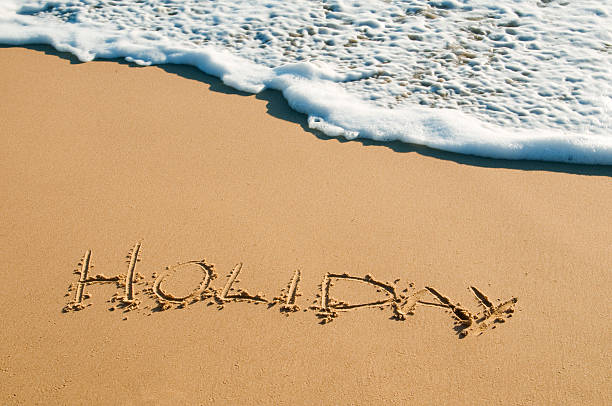 Holiday written on sand stock photo