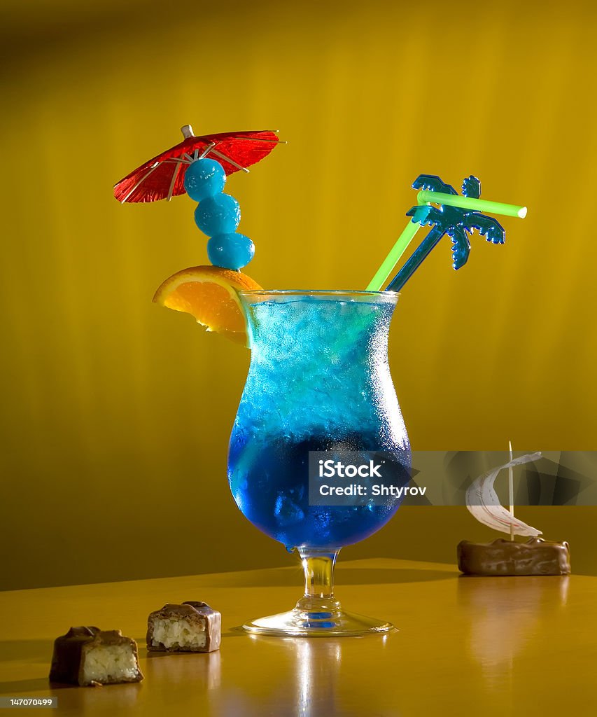 Cocktail "The Blue lagoon" Alcoholic cocktail of is bright-blue colour with the straws, decorated with fruit and chocolate. Alcohol - Drink Stock Photo