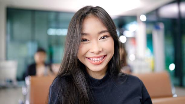 istock Attractive Asian female traveller smile looking at camera while waiting for her flight at airport terminal. travel idea concept 1470704992