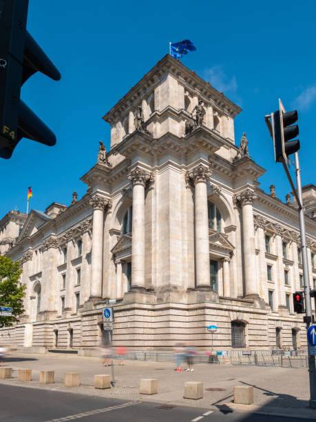 istock Bundestag Berlin Building, side view with traffic lights and people walking in front, long exposure, during summer with clear sky, vertical shot 1470705753