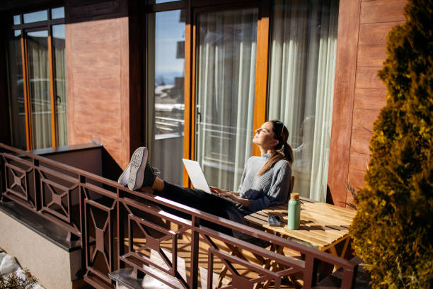 istock Young woman using laptop on balcony at morning 1470708917