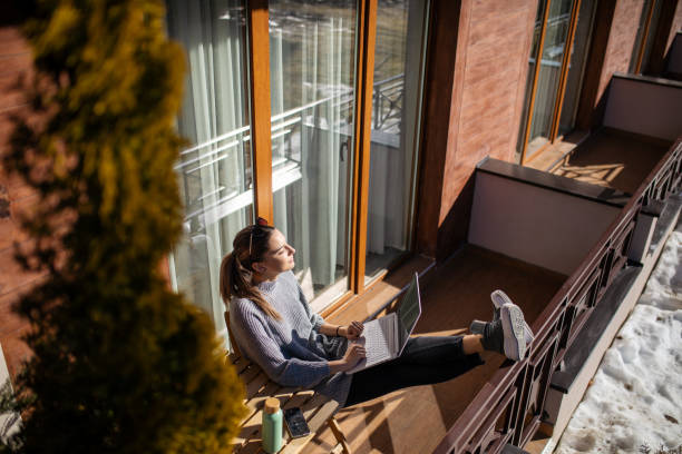 istock Young woman using laptop on balcony at morning 1470708918