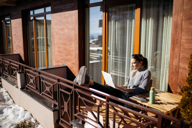 istock Young woman using laptop on balcony at morning 1470708921