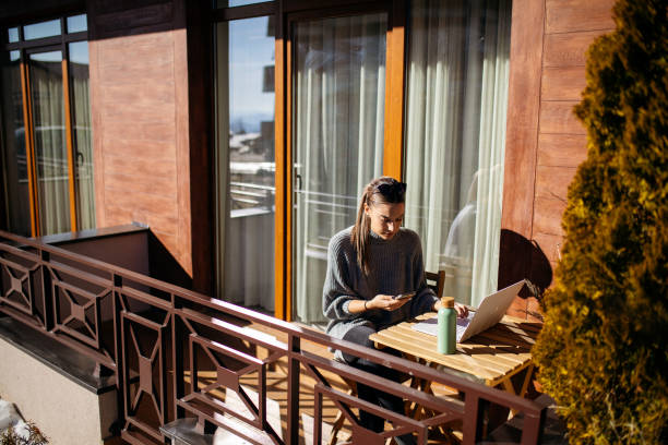 istock Young woman using laptop on balcony at morning 1470708923