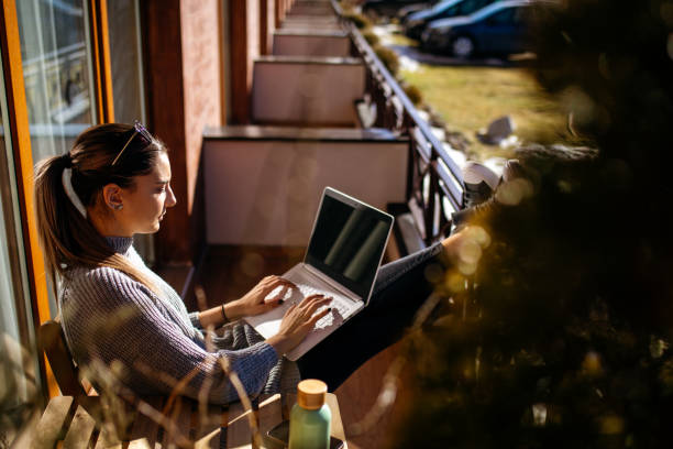 istock Young woman using laptop on balcony at morning 1470708942
