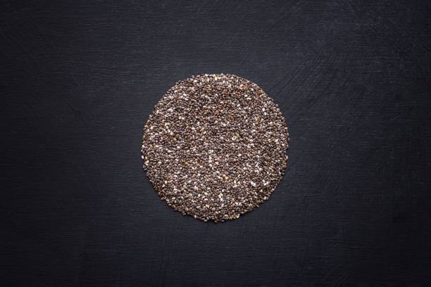 Top view of chia seeds shaped as a circle on a black background A top view of chia seeds shaped as a circle on a black background pileup stock pictures, royalty-free photos & images