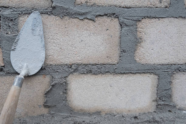 selectively focus on the dirty cement spoon because it is used to install bricks, in Indonesian the cement spoon is called cetok, soft focus stock photo