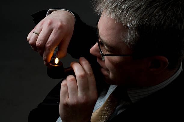 istock businessman lighting up tobacco pipe 147072288