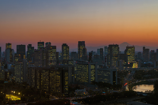 Tokyo, Japan - April 4, 2019: Sunset in Tokyo. View of the city center with the National Diet Building, modern skyscrapers and the iconic Mount Fuji
