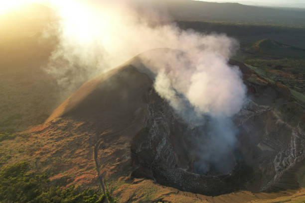 Volcanic masaya crater Volcanic masaya crater with big smoke cloud on sunset time background masaya volcano stock pictures, royalty-free photos & images
