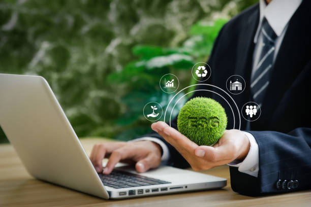 ESG Businessman is using computer and holding ESG icon. Environment, Society and Governance. concept illustrated with icons with beautiful green bokeh background. sustainable business stock pictures, royalty-free photos & images