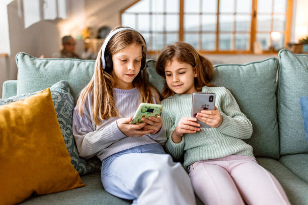 portret dwóch małych dziewczynek ze słuchawkami i telefonem komórkowym - six animals audio zdjęcia i obrazy z banku zdjęć