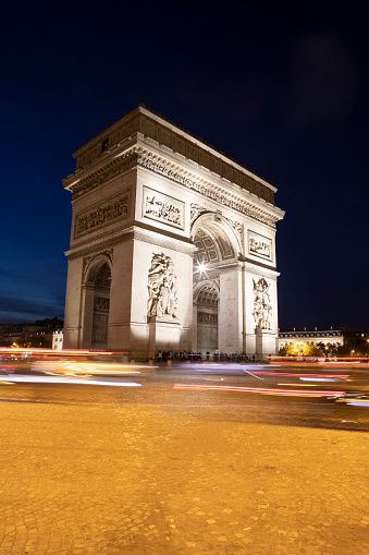 Blurred motion traffic at night around Arc de Triomphe