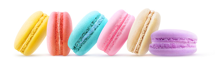 Multicoloured macarons in a row, isolated on white background
