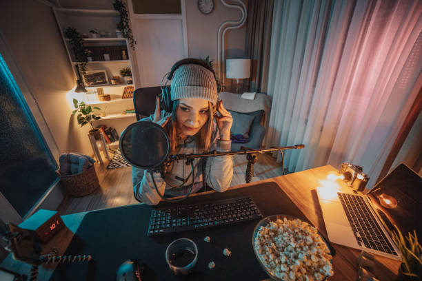 istock A young woman broadcasts or records a video podcast in a home studio from her room, using a microphone and headphones. 1470733059
