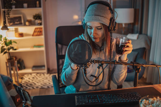 istock A young woman broadcasts or records a video podcast in a home studio from her room, using a microphone and headphones. 1470733161
