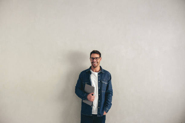 istock Happy young businessman smiling while holding a laptop 1470733233