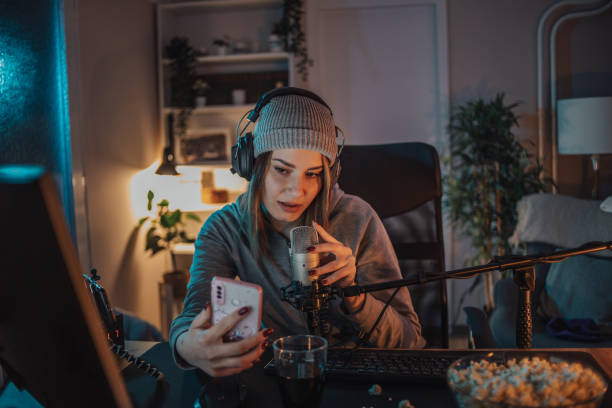istock A young woman broadcasts or records a video podcast in a home studio from her room, using a microphone and headphones. 1470733834