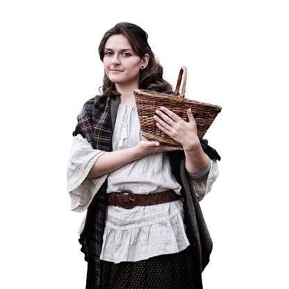 Happy young woman with wicker basket in hands, isolated on a white background. Woman in a retro dress on a background of an old house