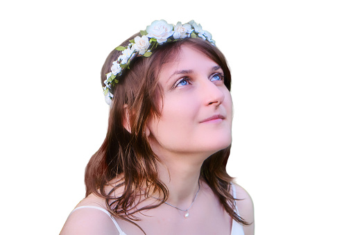 Woman in a white dress with a wreath on her head looks up, copy space for text, isolated on a white background