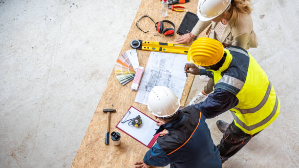 istock Contractors discussing blueprint at table top view 1470735384