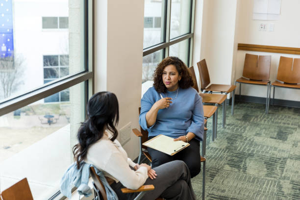 istock Female counselor gestures while advising unrecognizable woman 1470735610