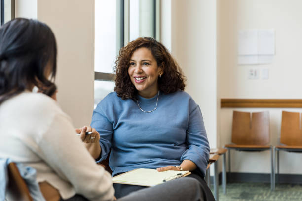 istock Therapist smiles and gestures to unrecognizable female client 1470735625