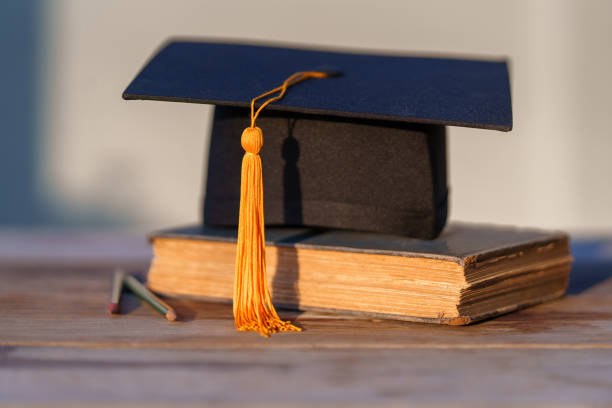 istock Graduation Cap university pace on wood table graduation concept 1470735703