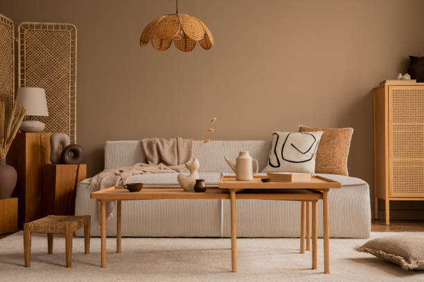 istock Creative composition of living room interior with modular sofa, wooden coffee table, rattan sideboard, beige rug, pillows and personal accessories. Home decor. Template. 1470737023