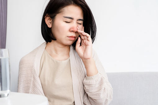 Asian women have stuffy nose having a runny nose and bad breath caused by sinus infection