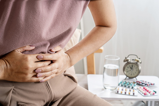 irritable bowel syndrome IBS concept with woman hand holding a stomachache having problems with the digestive system like diarrhea and constipation