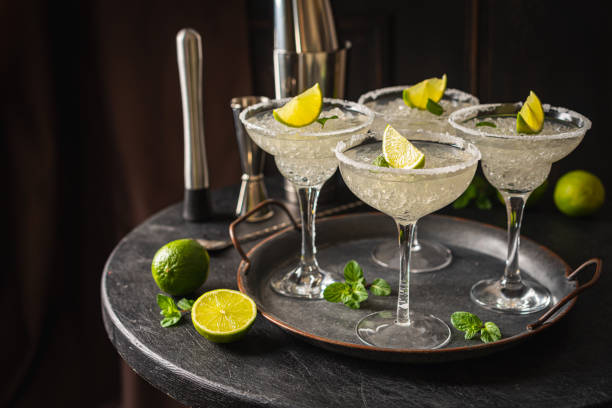 Margarita cocktail with lime Margarita cocktail with lime and ice on dark wooden table with copy space. Classic Margarita and Daiquiri Cocktail. daiquiri stock pictures, royalty-free photos & images