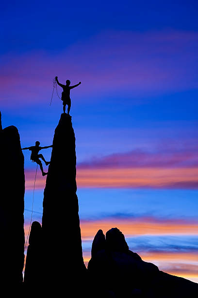 istock Team of rock climbers reaching the summit. 147074082