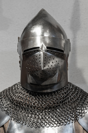 Medieval knight armor, closed iron helmet and chain mail over torso armor, front view