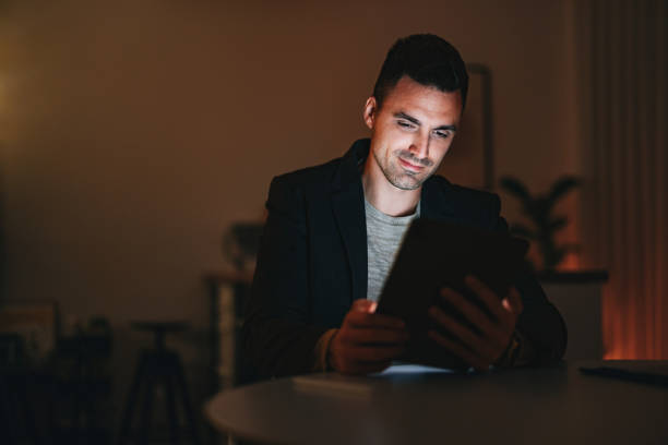 istock Smiling Businessman Using A Digital Tablet At Home Office At Night 1470741884