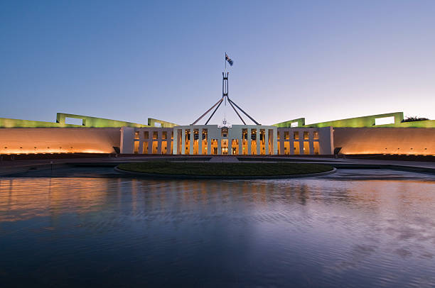 australische parlament house, canberra, handeln beleuchtet bei dämmerung - parlamentsgebäude regierungsgebäude stock-fotos und bilder