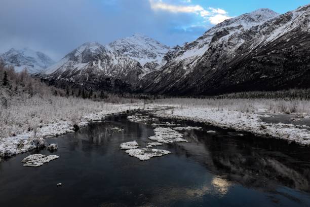 istock Landscape of a river surrounded by snowy mountains under a cloudy sky 1470743214