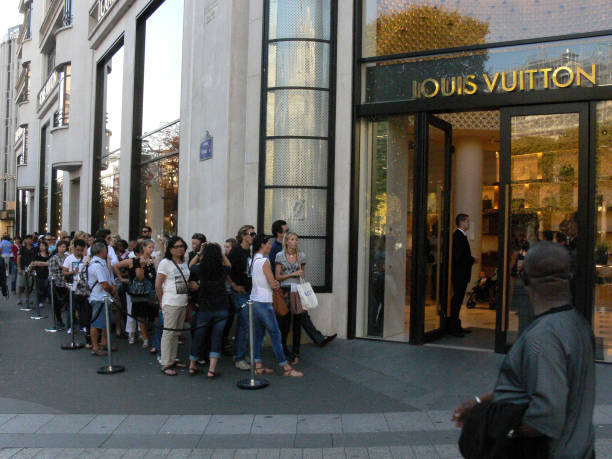 People queuing in front of a Louis Vuitton store in Paris, France. stock photo