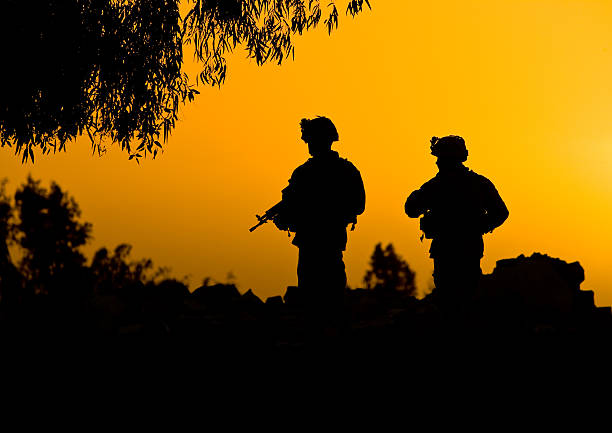 Soldier silhouettes in sunset stock photo